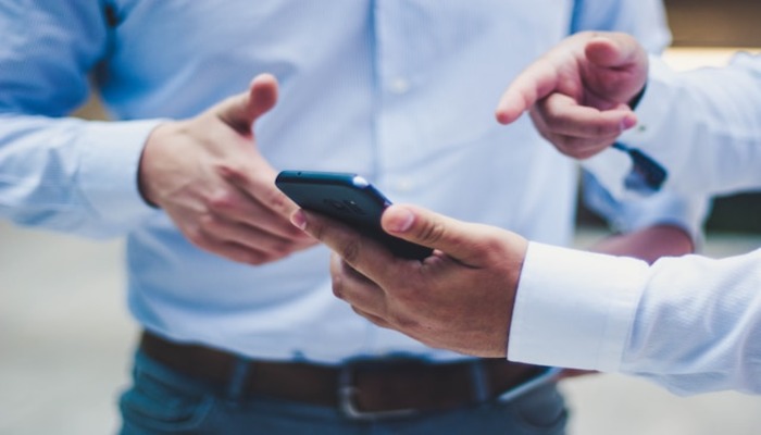 An undated image of two persons using a mobile phone. — Unsplash