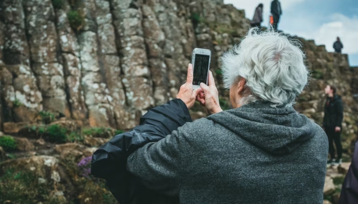 An undated image of an elderly person capturing a photo. — Unsplash