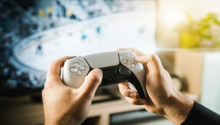 An undated image of a person with a gaming controller. — Unsplash