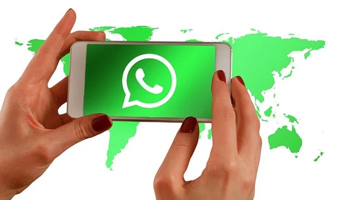 An undated image of a girl holding a phone with WhatsApp logo displayed on the screen. — Pixabay