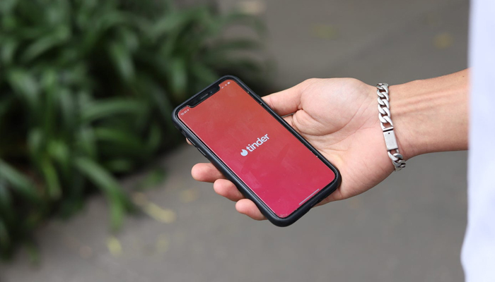 An undated image showing Tinder logo on a smartphone. — Unsplash