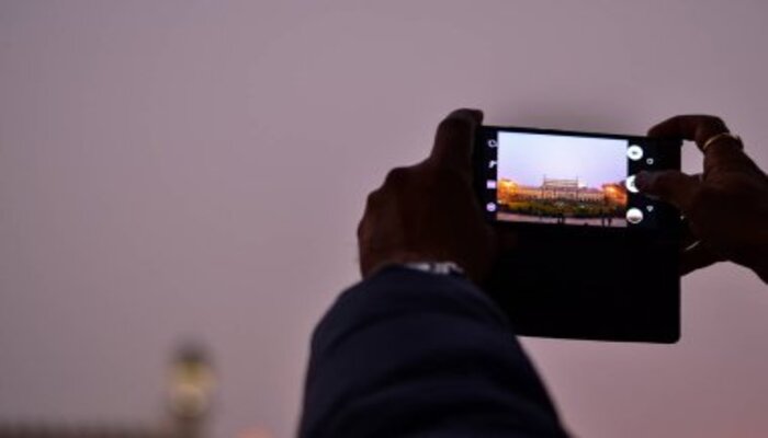 An undated image of a person taking picture with phone. — depositphotos