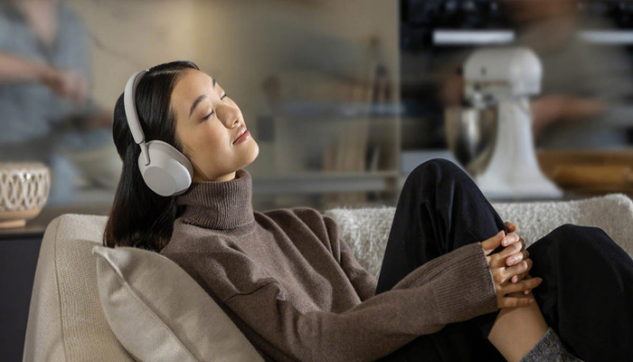 An undated image of a person wearing Sony WH-1000XM5 headphones. — Sony