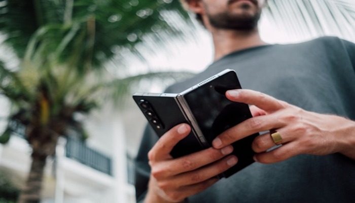An undated image of a person holding a foldable smartphone. — Unsplash