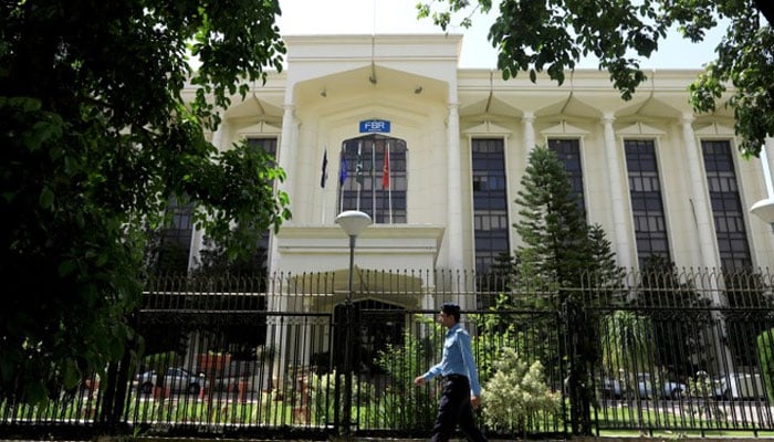 A policeman walks past the Federal Board of Revenue (FBR) office building in Islamabad, August 29, 2018. — Reuters