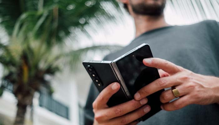 An undated image of a person holding a foldable phone. — Unsplash