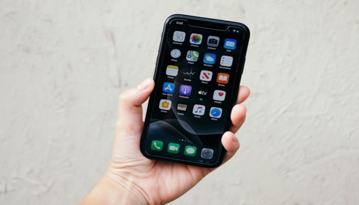 An undated image of a person holding a phone. — Unsplash