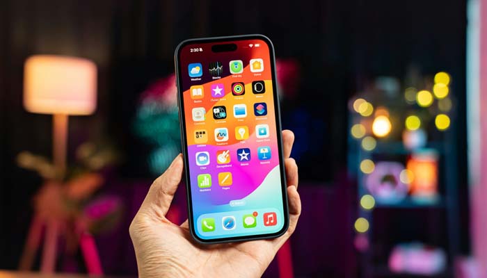 An undated image of a person holding iPhone 15. — Unsplash