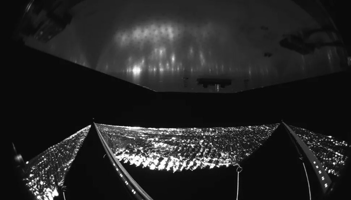 A black-and-white image os the silvery sheet of solar sail toward the bottom. — NASA