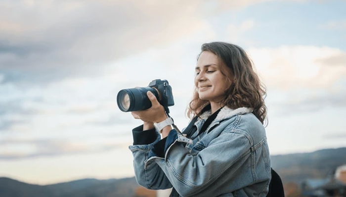 An undated image showing a girl using camera. — ShutterStock