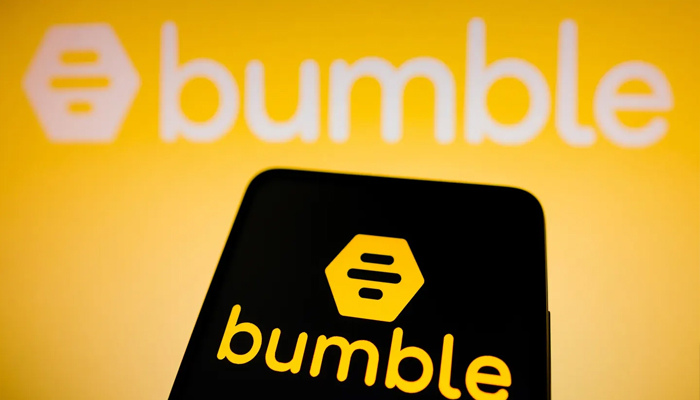 An undated image showing Bumble logo displayed on a smartphone and in the background. — Getty Images