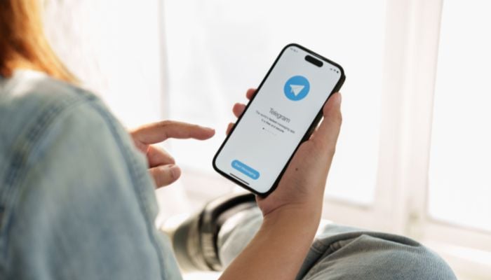 An undated image of a person using Telegram app. — Canva