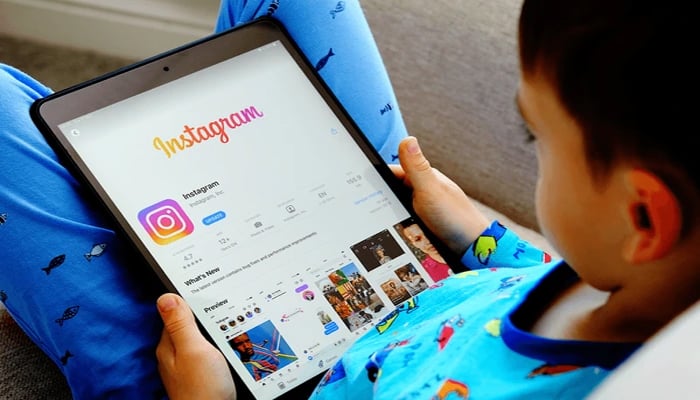 An undated image showing a kid using an iPad on which the Instagram installation interface shown on App store. — iStock