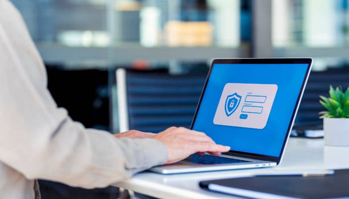 An undated image showing a person using laptop while opened a password manager app. — iStock