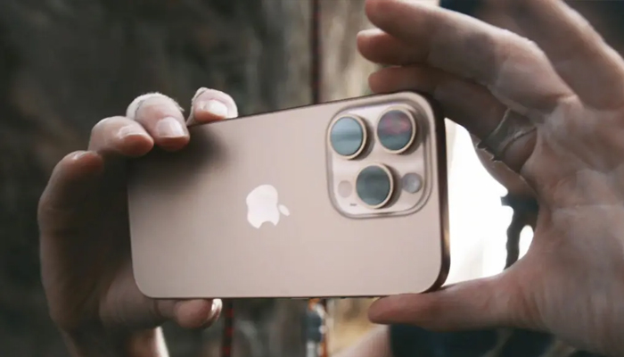 An undated image showing a person using camera app on iPhone 16. — Apple