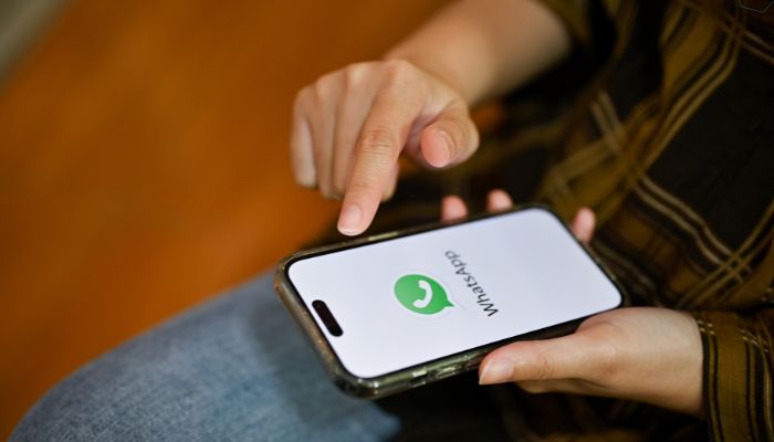 An undated image of a person using WhatsApp. — Canva