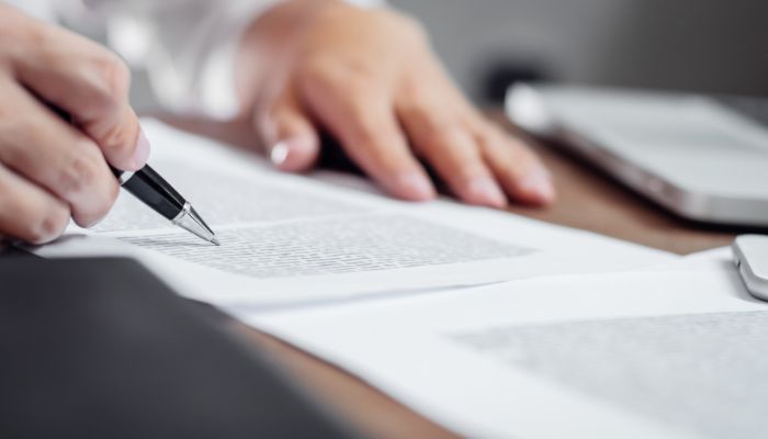 An undated image of a person reviewing documents. — Canva