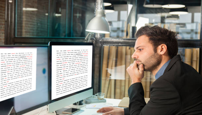 An undated image showing a person proofreading a text. — iStock