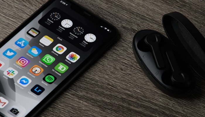 An undated image showing an iPhone along with airpods. — Unsplash