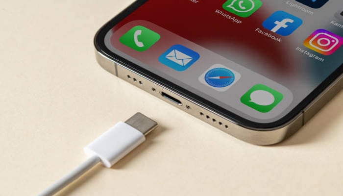 An undated image showing an iPhone ready to be connected with a charging cable. — iStock