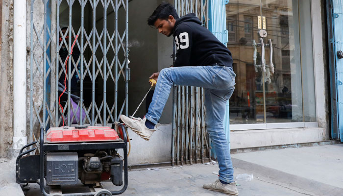 A man starts a generator outside his shop during a country-wide power breakdown in Karachi, Pakistan January 23, 2023. — Reuters