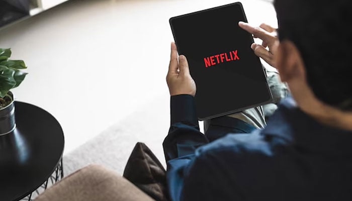 An undated image of a person using Netflix on his iPad — Freepik
