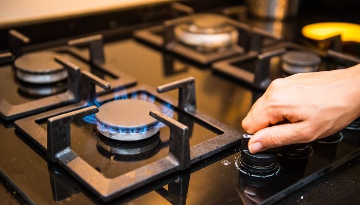 An undated image of a person using a gas stove. — Canva