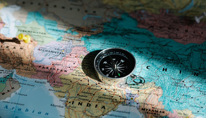 An undated image of compass on a world map. — Pexels