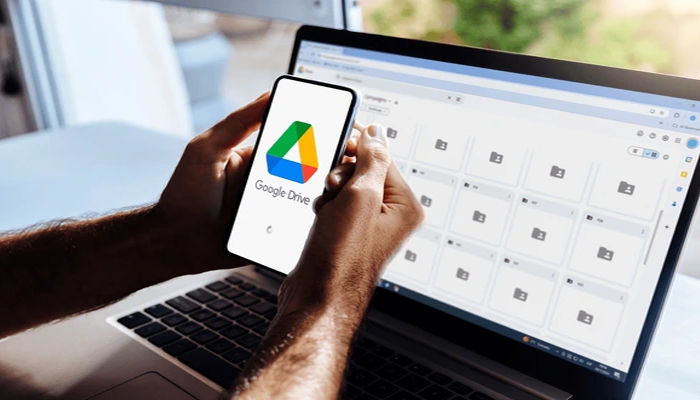 An undated image of the Google Drive logo on a smartphone, along with an interface displayed on a laptop. — Shutterstock