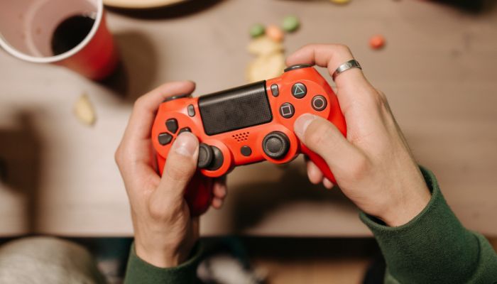 An undated image of a person holding a gaming console. — Canva