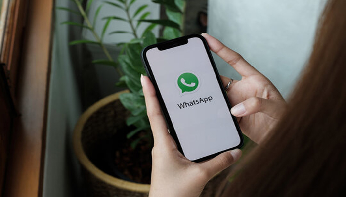 An undated image of WhatsApp logo displayed on a iPhone. — Adobe Stock