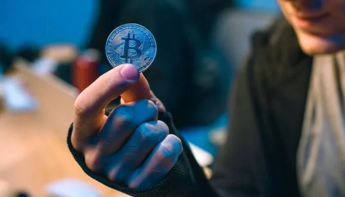 An undated image of a person holding a Bitcoin. — Depositphotos