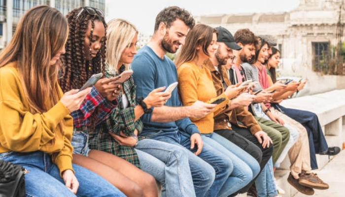 An undated image of a group of people using their phones. — Shutterstock