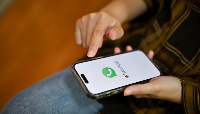 An undated image of WhatsApp logo displayed on a smartphone. — Canva