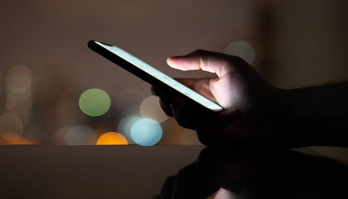 An undated image of a person seeing bright HDR content on a smartphone. — iStock