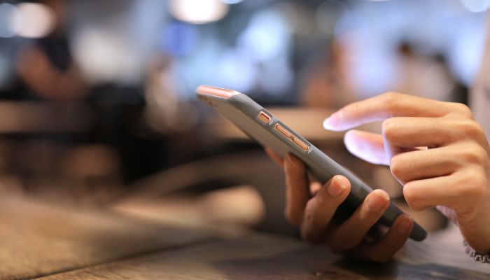 An undated image of a person using a phone. — Canva