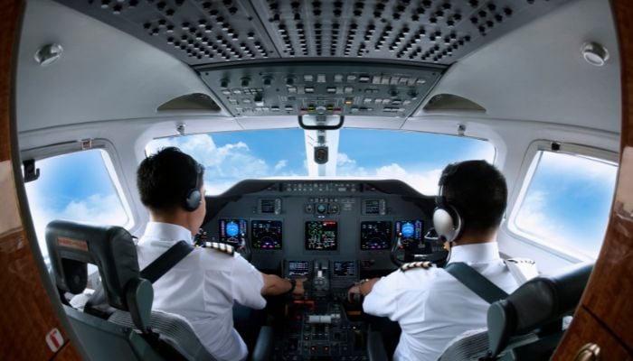 An undated image of pilots in an airplane cockpit. — Canva
