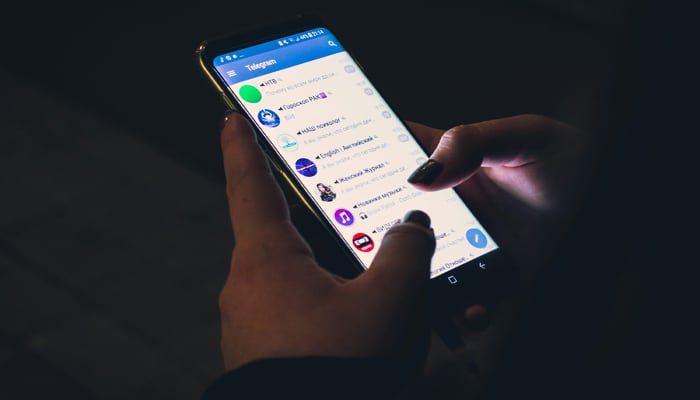 An undated image showing a person using Telegram. — Unsplash