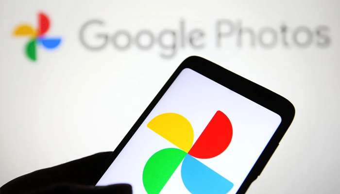 An undated image of Google Photos app logo is displayed on a smartphone and in the background. — Getty Images