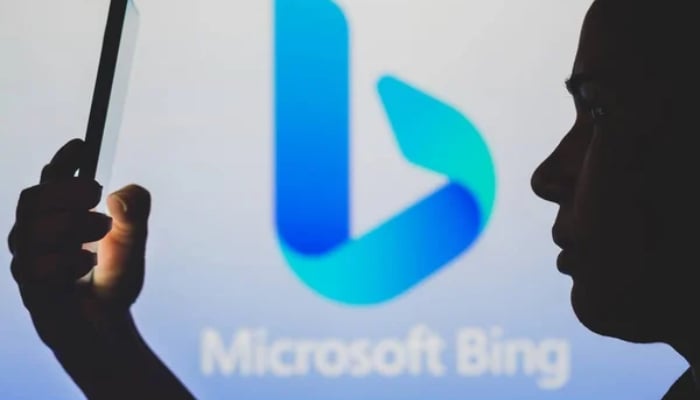 An undated image of a person using smartphone with Microsoft bing logo in the background. — Depositphotos