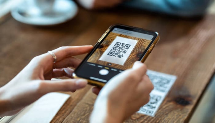 An undated image showing an iPhone scanning QR code. — iStock