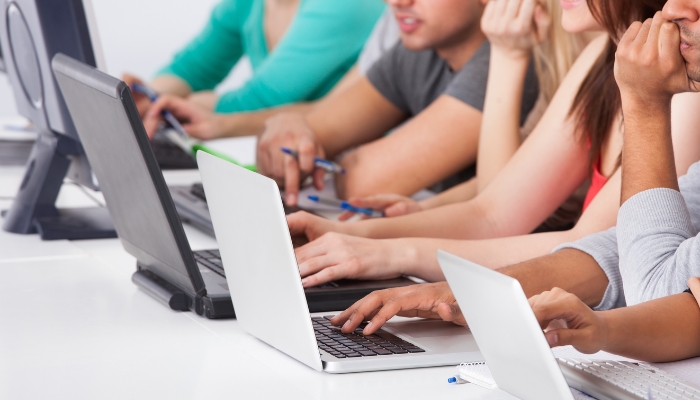 An undated image of people using laptops. — Canva
