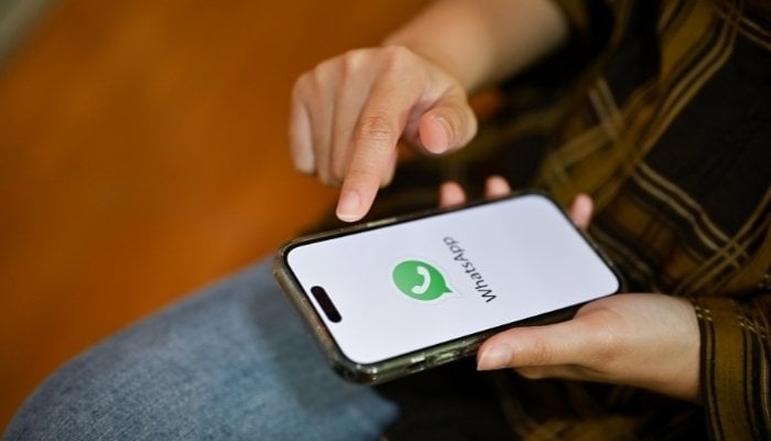 An undated image of WhatsApp logo displayed on a smartphone. — Canva