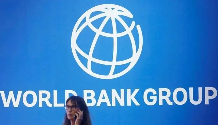 A participant stands near a logo of World Bank at the International Monetary Fund - World Bank Annual Meeting 2018 in Nusa Dua, Bali, Indonesia, October 12, 2018. — Reuters
