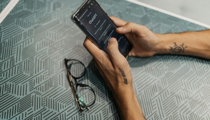 An undated image of a person using ChatGPT on a phone. — Canva
