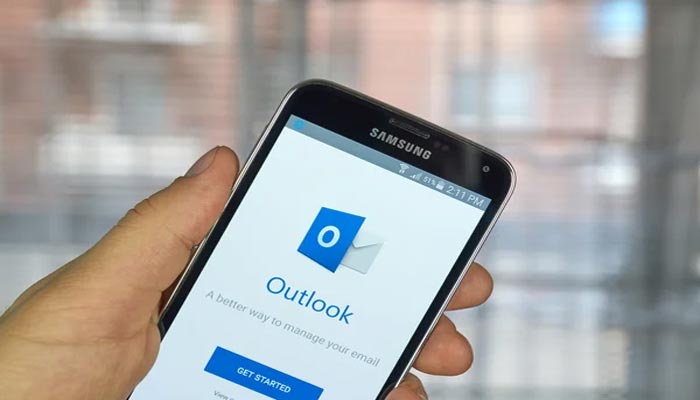 An undated image of a person using Outlook on mobile. — Depositphotos