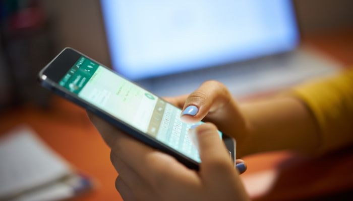 An undated image of a person using WhatsApp. — Canva