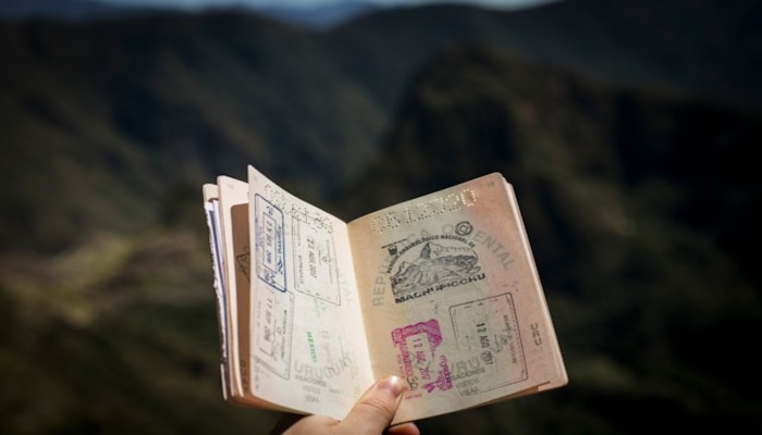 An undated image of a person holding passport. — Unsplash