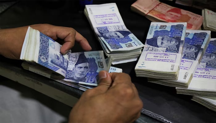 An employee counts Pakistani rupee notes at a bank in Peshawar, Pakistan August 22, 2023. — Reuters
