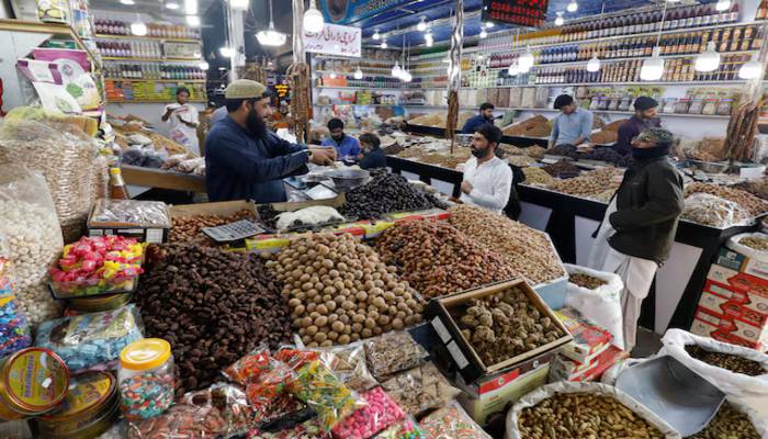 People buy dry fruits at a market in Karachi, Pakistan February 1, 2023. — Reuters